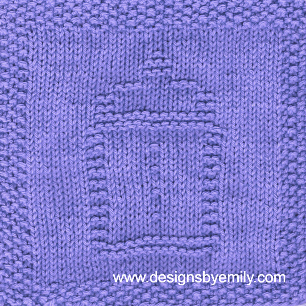 Baby Bottle Knit Dishcloth: A handmade knitted dishcloth square in purple yarn displaying a design of a baby bottle in the center. The design is created in garter stitch using knit and purl stitches on a stockinette background.