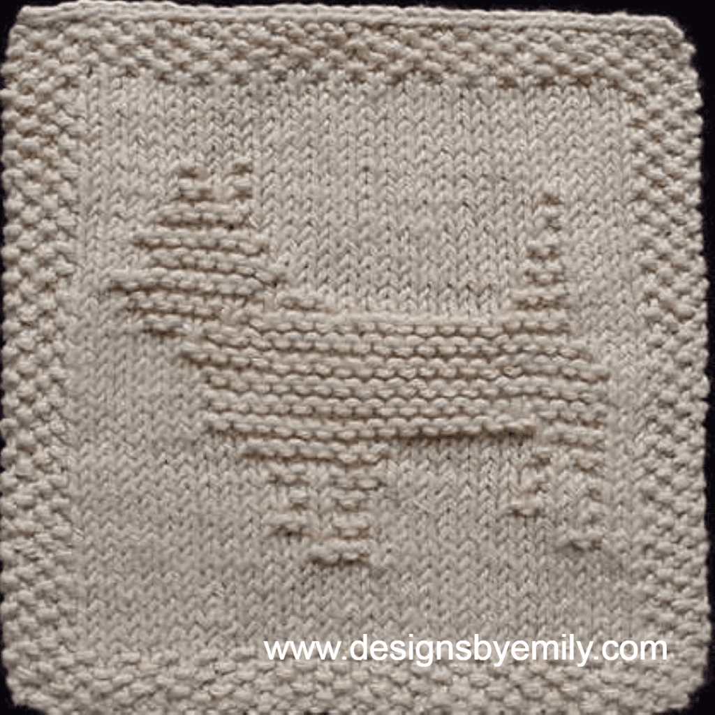 Cairn Terrier Knit Dishcloth: A handmade knit dishcloth square in tan yarn featuring a cairn terrier dog in the center facing toward the left. The design is created in garter stitch using knit and purl stitches on a stockinette background.
