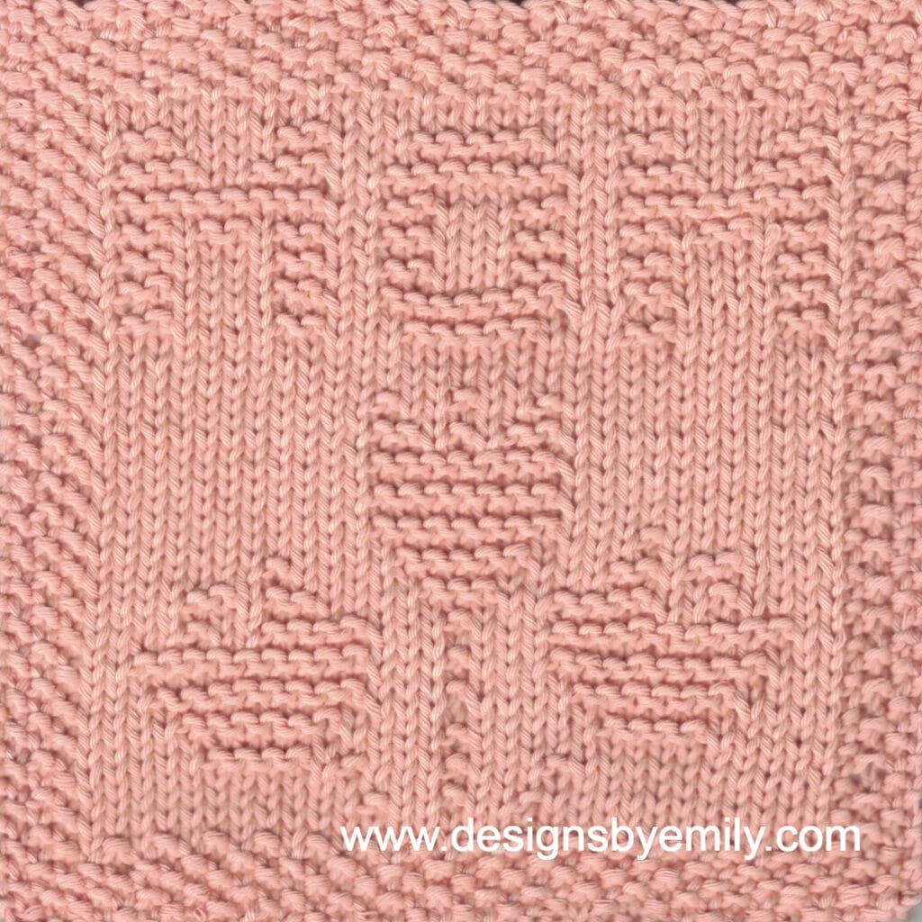 Flowers for Mom Knit Dishcloth: A handmade knit dishcloth square in peach yarn with the word MOM at the top and a trio of tulips centered underneath. The design is created in garter stitch using knit and purl stitches on a stockinette background.