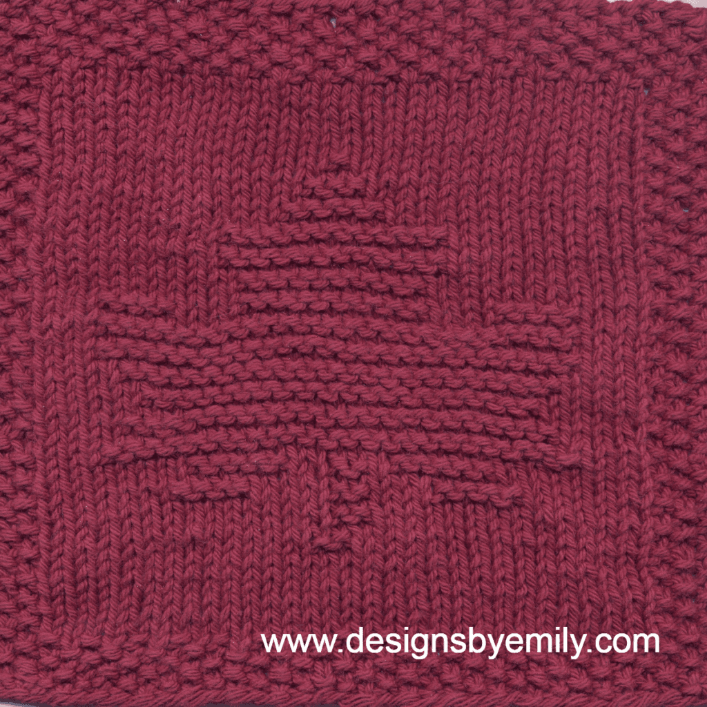 Maple Leaf Knit Dishcloth: A handmade knit dishcloth square in dark red yarn featuring a maple leaf. The design is created in garter stitch using knit and purl stitches on a stockinette background.