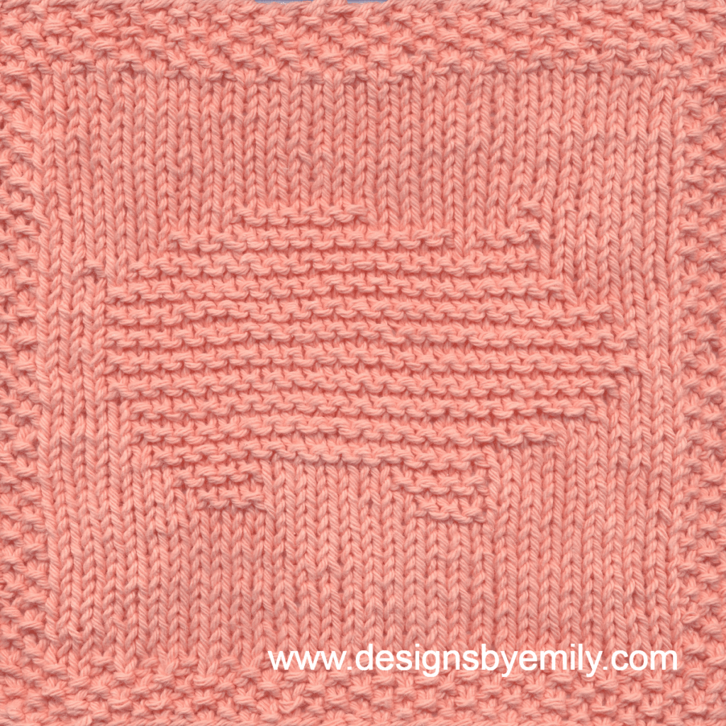 Pig Knit Dishcloth: A handmade knitted square in peach yarn featuring the profile of a stout pig with a curly tail, facing to the right. The design is created in garter stitch using knit and purl stitches on a stockinette background.