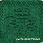 Shamrock Knit Dishcloth: A handmade knitted dishcloth square in deep green yarn featuring a three-leaf shamrock. The design is created using knit and purl stitches.