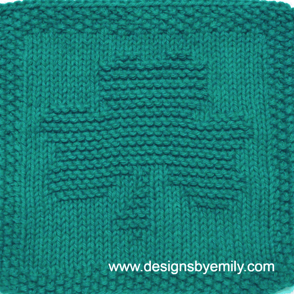Shamrock Knit Dishcloth: A handmade knitted dishcloth square in teal yarn featuring a three-leaf shamrock. The design is created using knit and purl stitches.